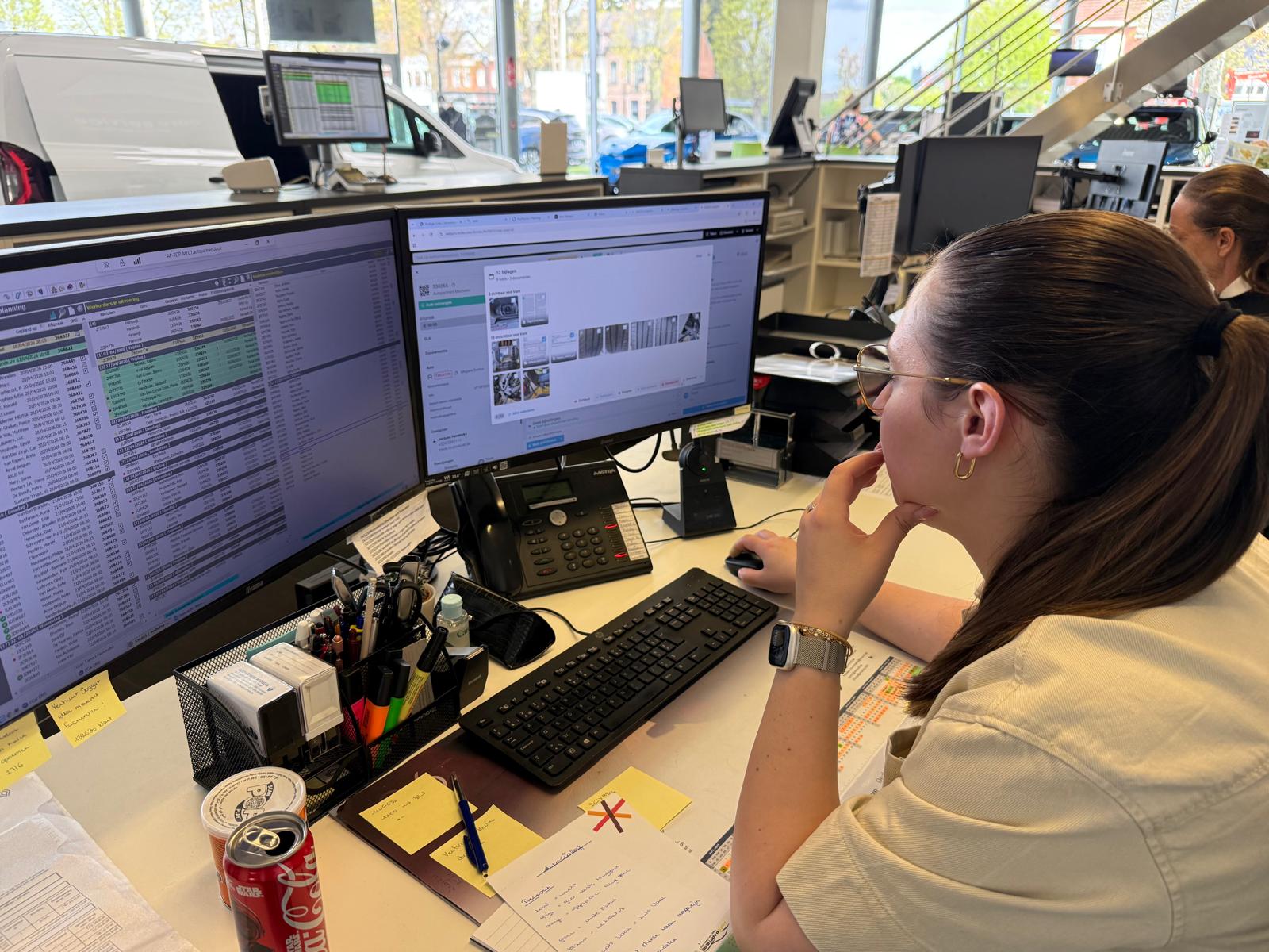 Service advisor working the daily planning and live dossiers on dual monitors